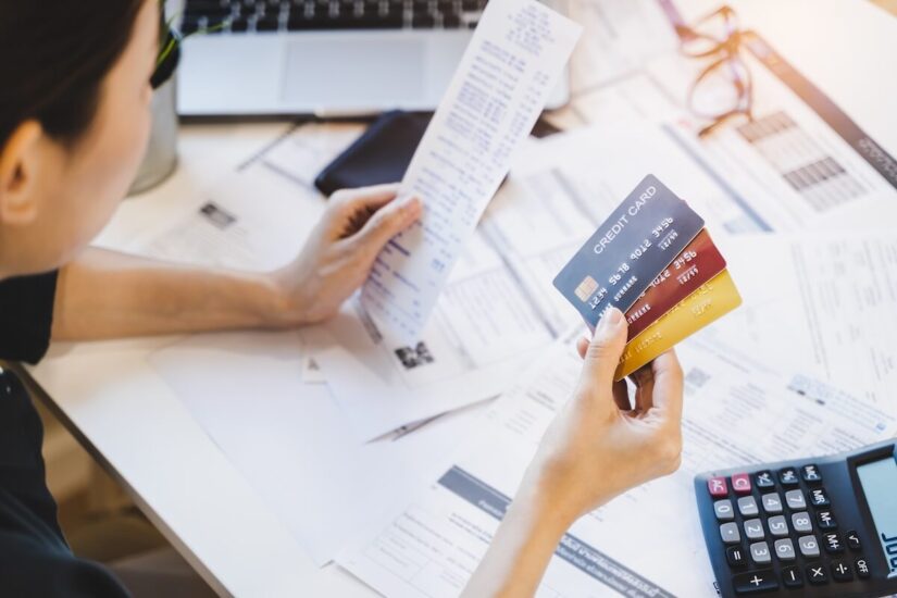 Woman looking at many credit cards in her hand and worried about loan debt payment